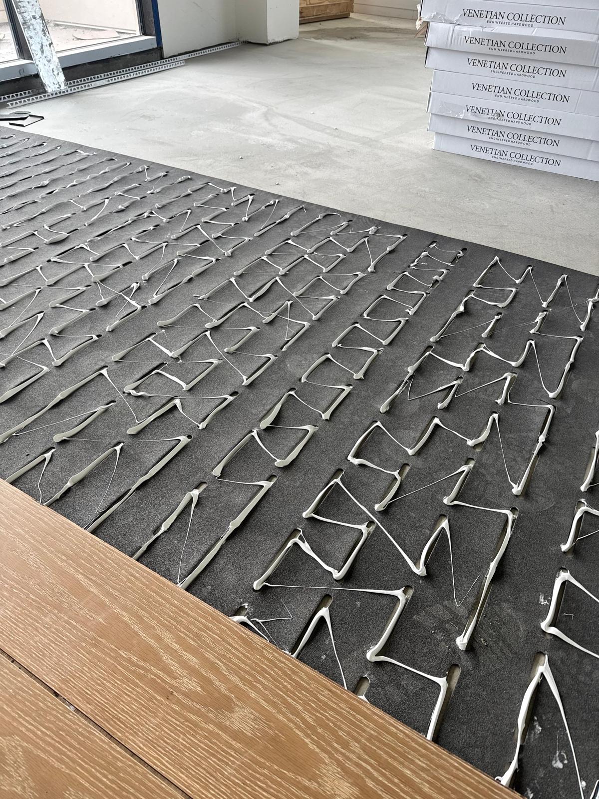 Troweled adhesive over acoustic underlayment with Venetian Collection engineered hardwood boxes